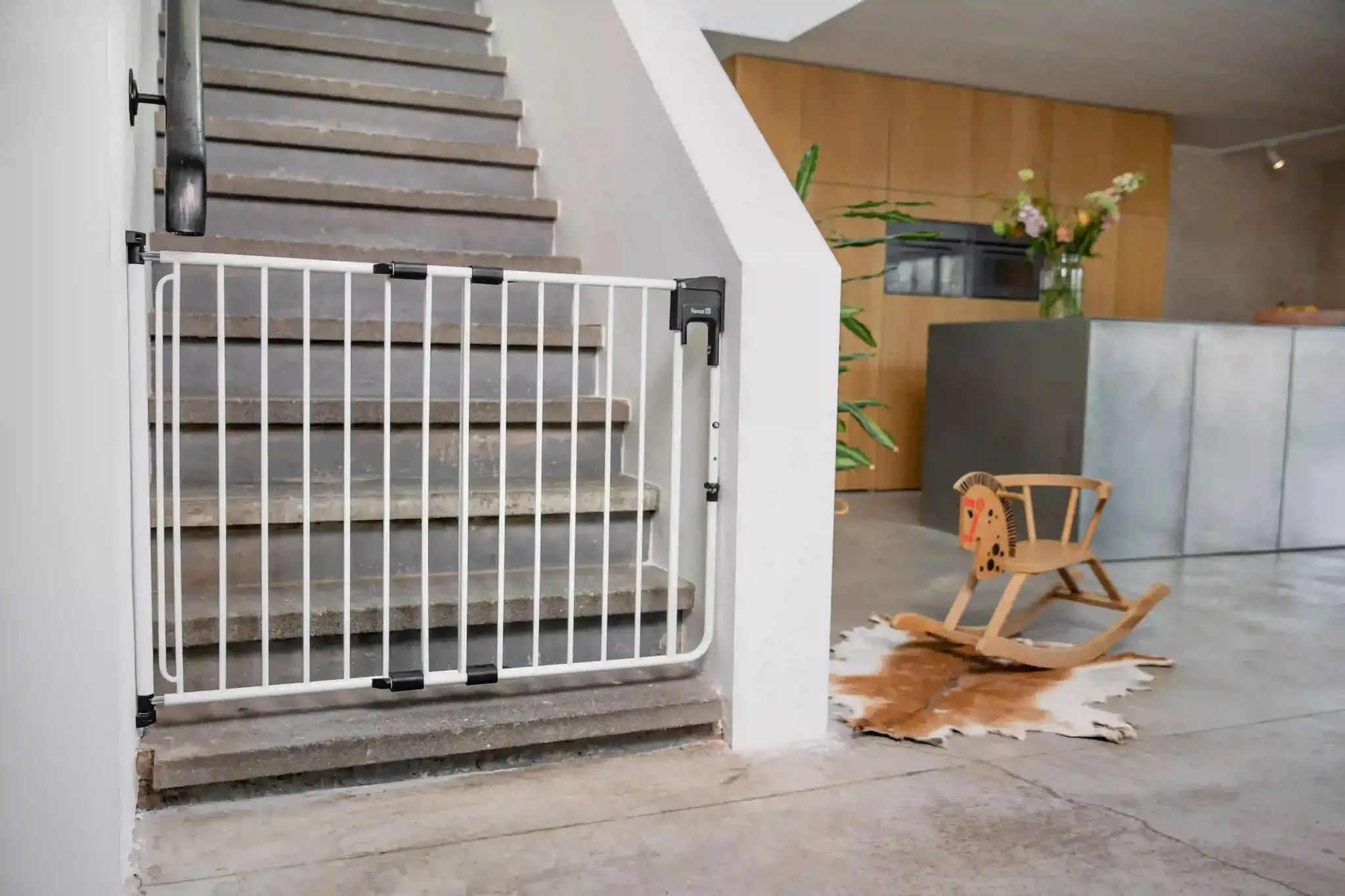 Pressure-fit stair gate installed at the bottom of a staircase